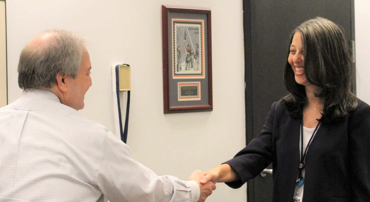 Mass General Brigham’s Elsie Taveras, MD, shaking hands with an individual in a city hall office
