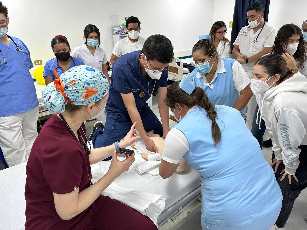 Physician teaching CPR to a room full of health care professionals