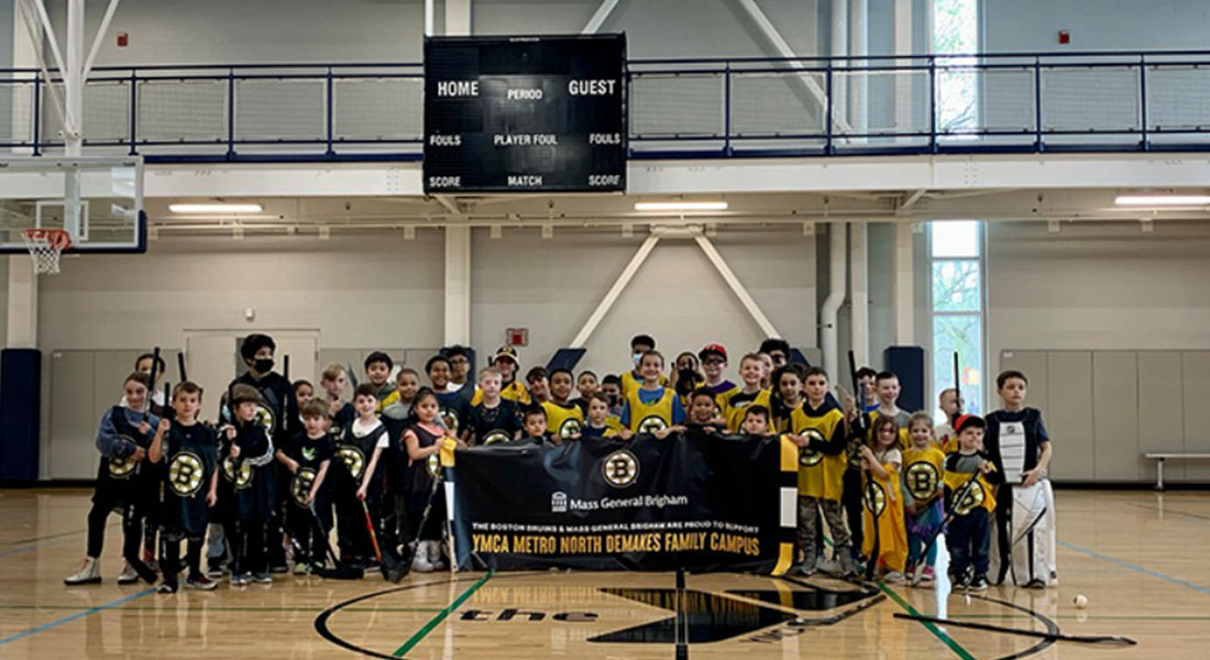 group photo with children and participants from the Boston Bruins youth street hockey clinic