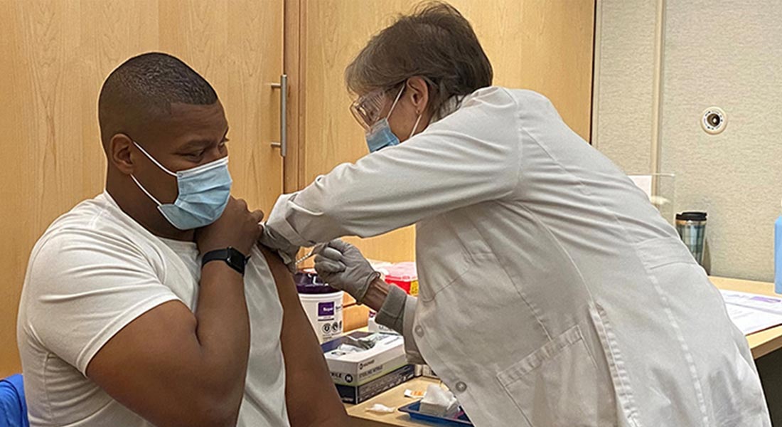 man receiving vaccine from healthcare worker