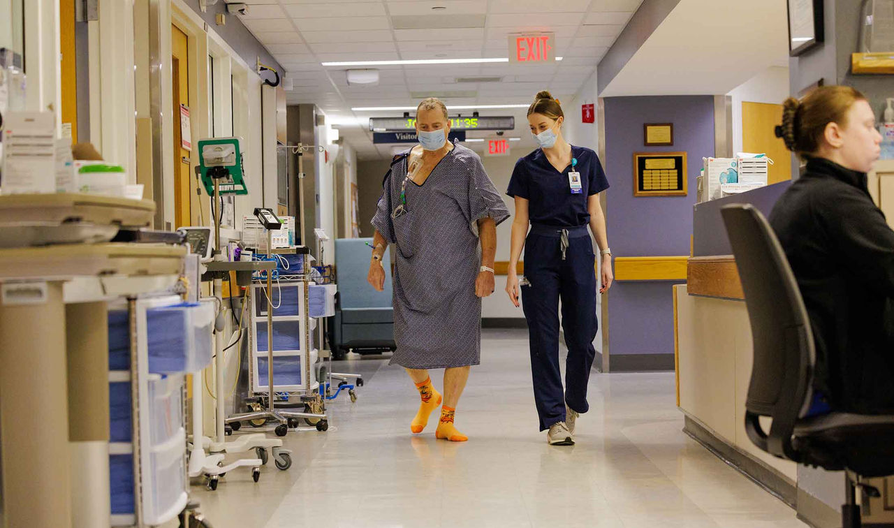 Tim walking through hall with his nurse