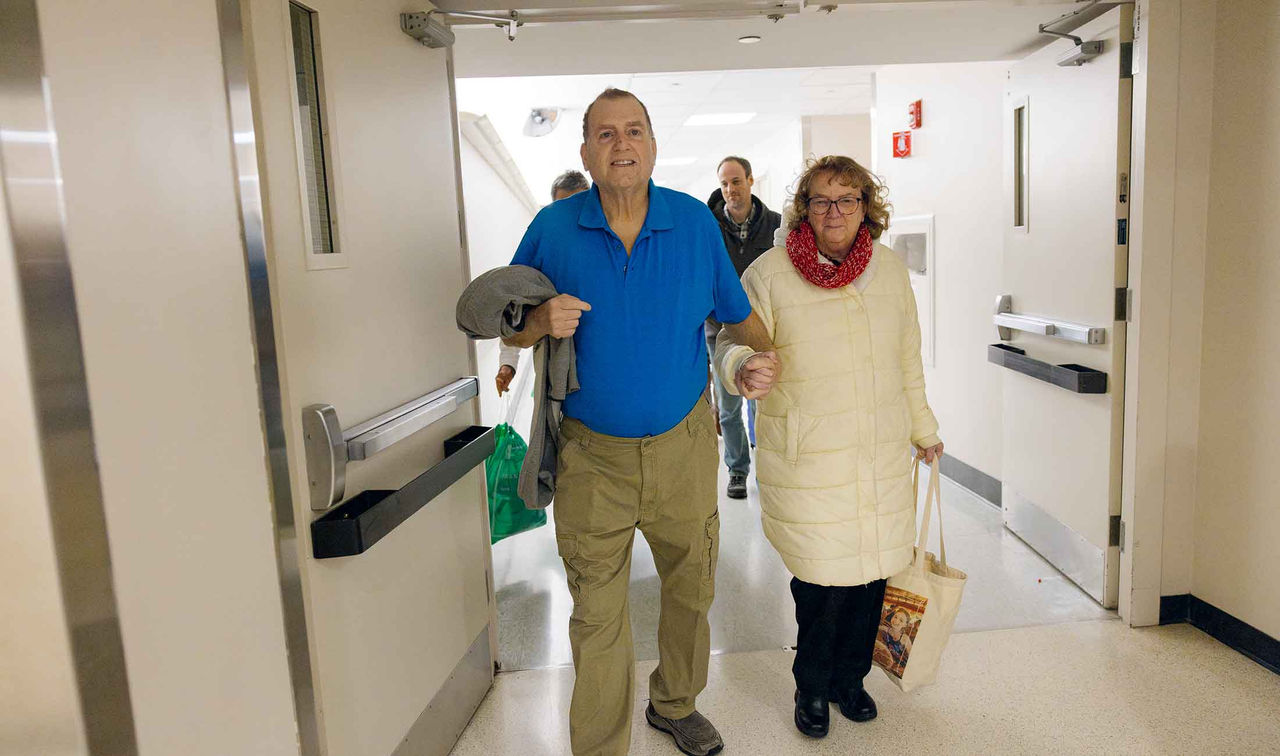 Tim and his wife walking through hospital corridor