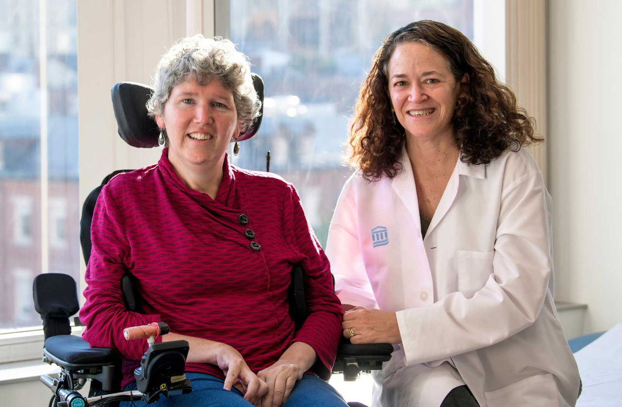 Merit Cudkowicz, MD, MSc with a patient.