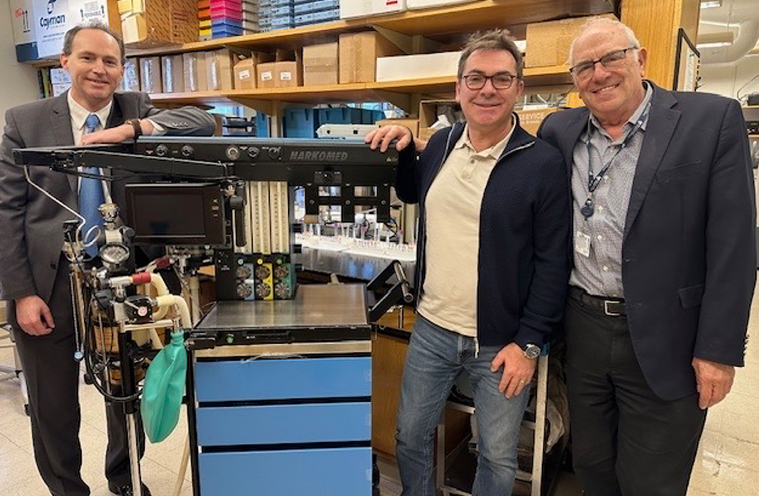 Three researchers in a research lab at Brigham and Women’s Hospital pose next to a machine used to deliver Xenon gas