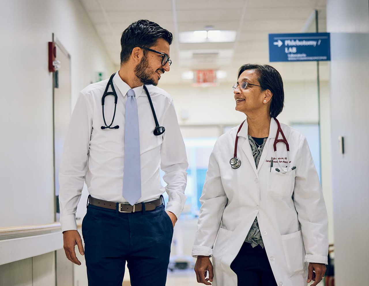 male and female clinicians conversing in hallway