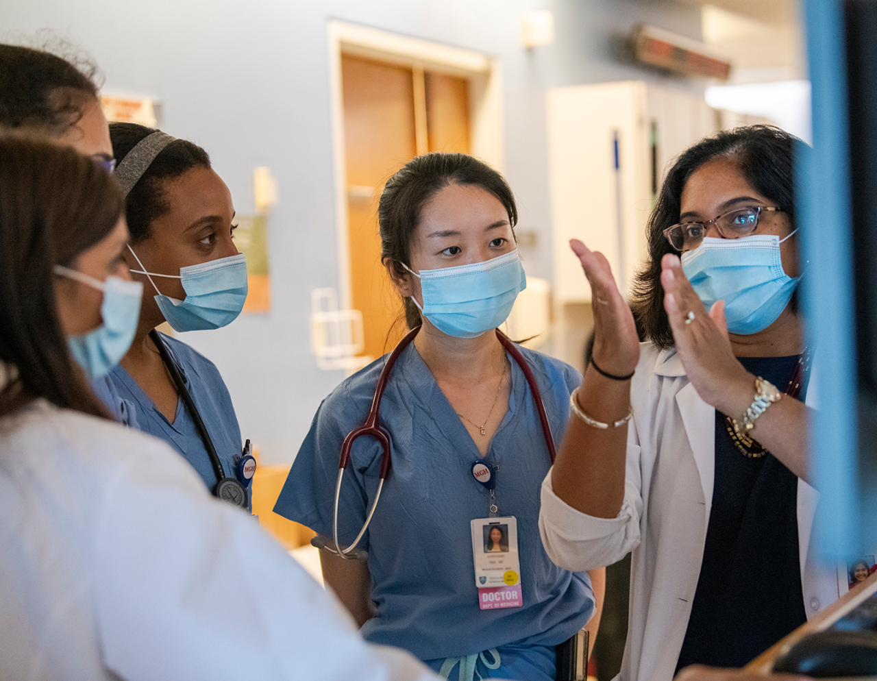 doctors and trainees performing rounds on patient floor 