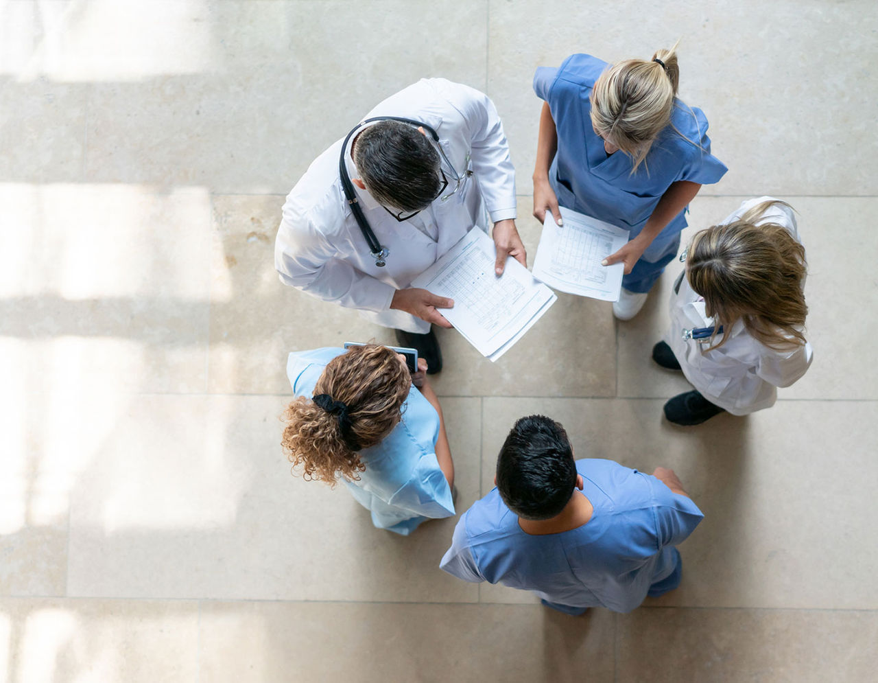 top view of five providers huddling in circle