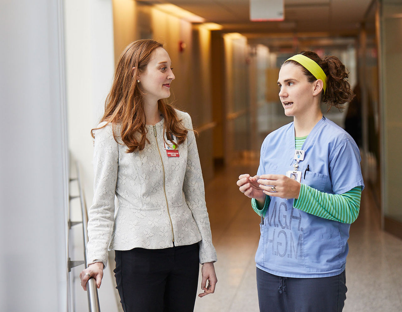 administative fellow and nurse talking in hallway