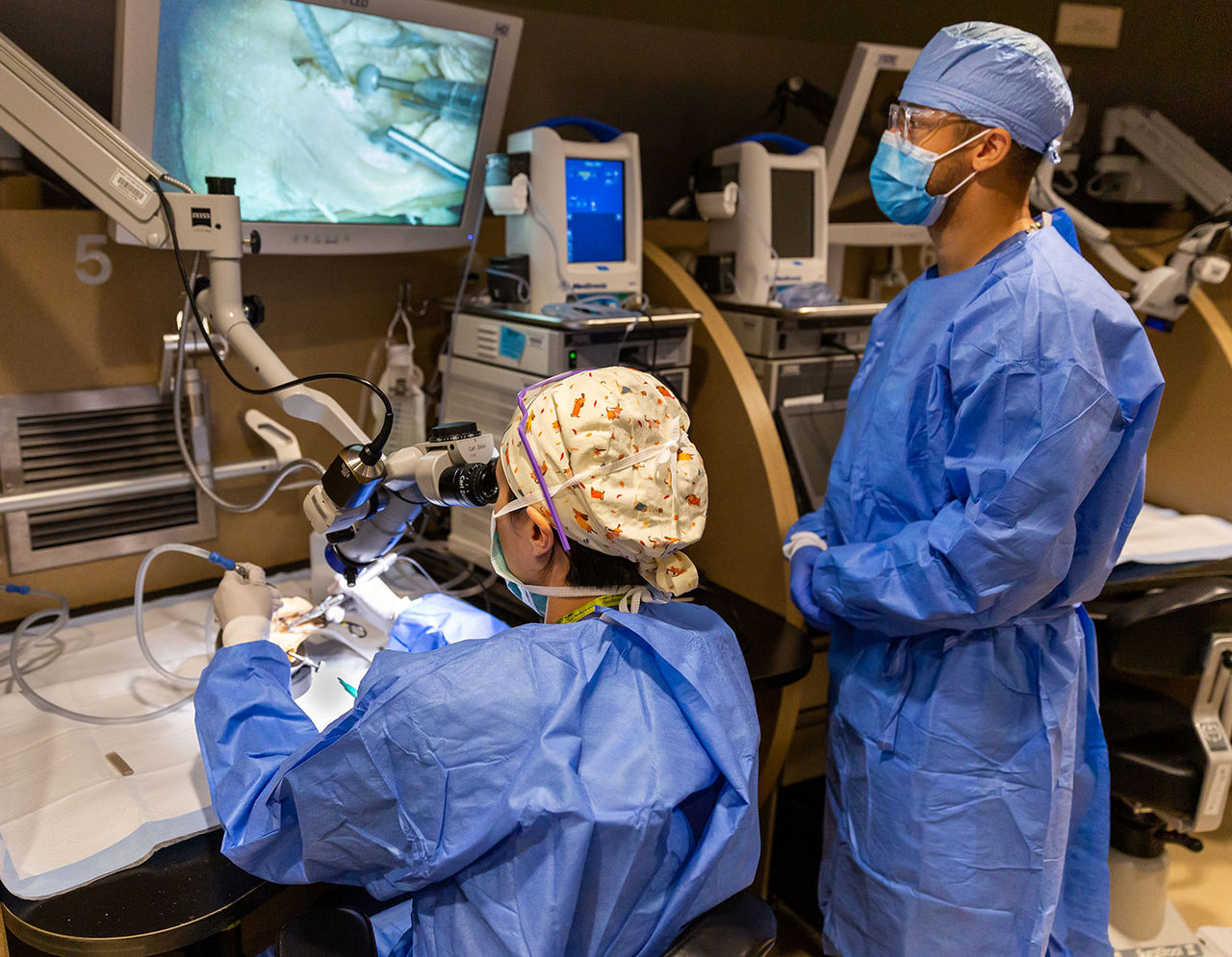 clinician watching trainee use equipment in Mass Eye and Ear surgical training lab