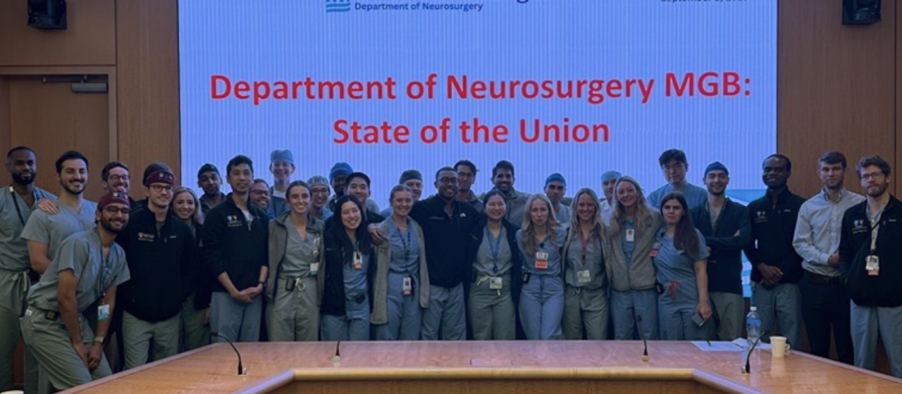 Group of neurosurgery residents in front of a projector screen