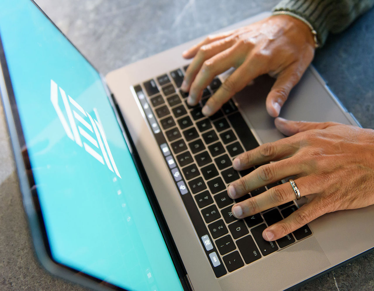 closeup of person's hands typing on laptop 