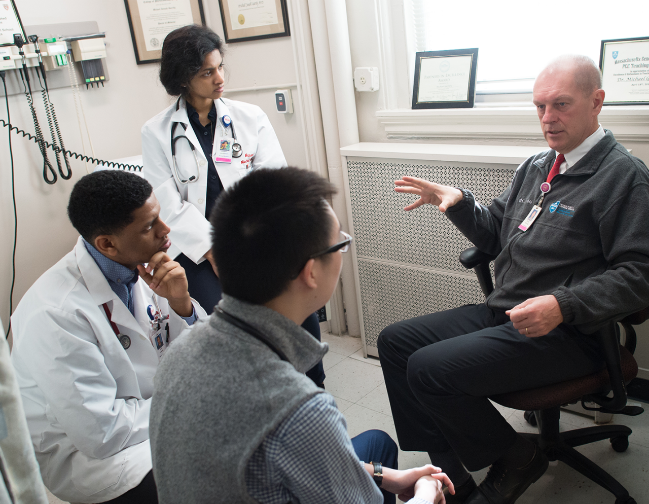 doctors and trainees discussing a patient case in an exam room
