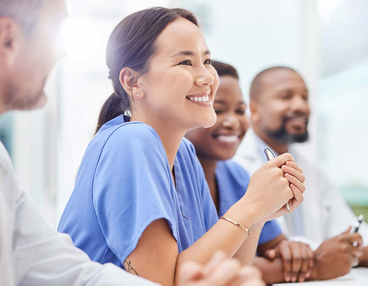 group of clinicians smiling during a meeting