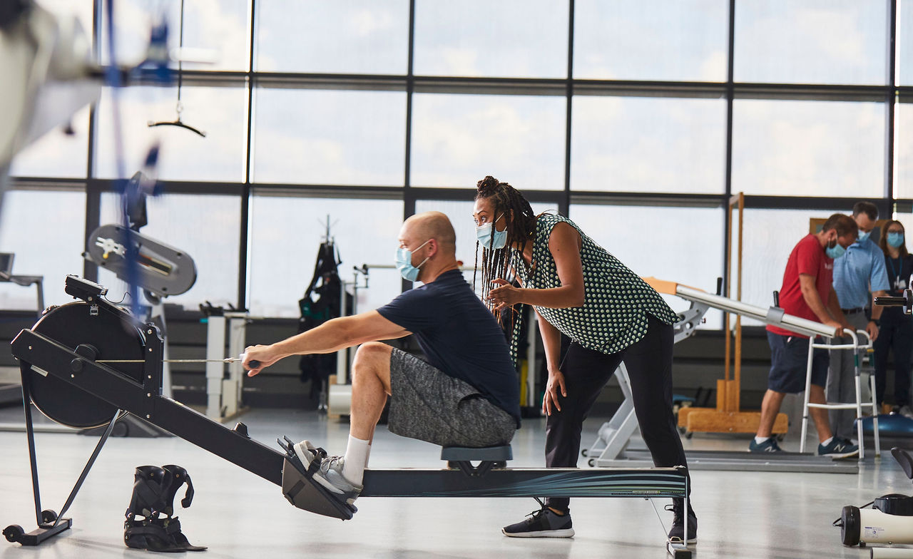 Physical therapist and patient on rowing machine 