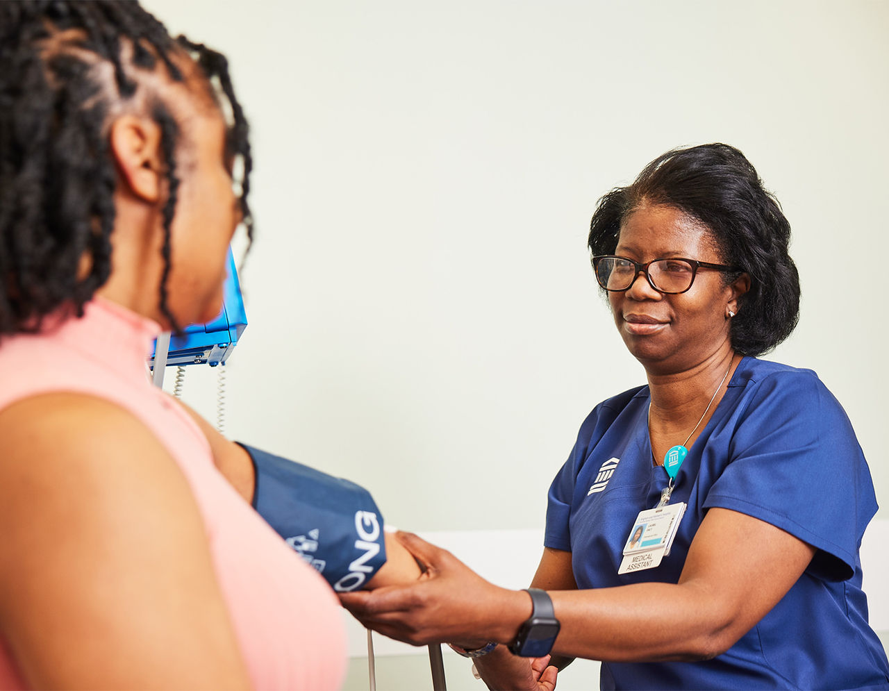 Doctor wearing a mask and stethoscope speaks with a patient