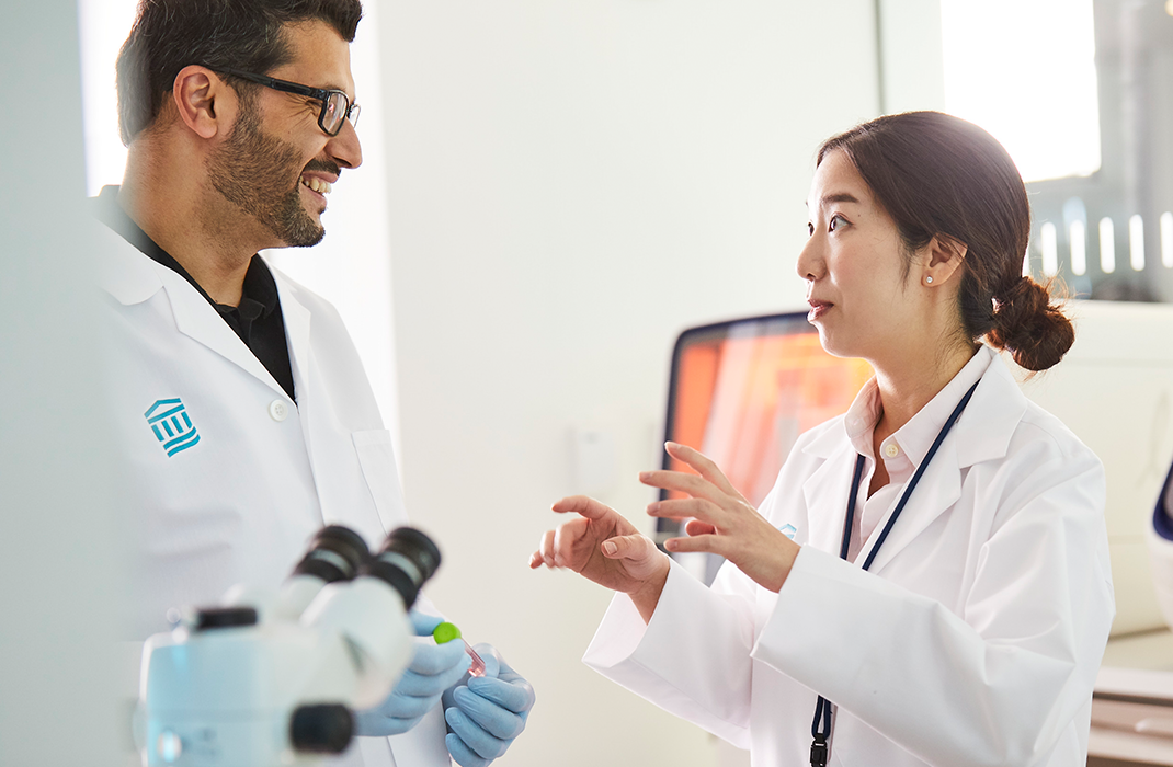 Male and female researchers talking in lab