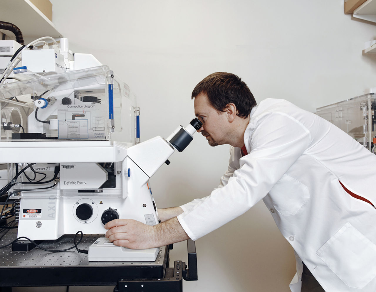 Doctor using a confocal microscope equipped with an incubator 