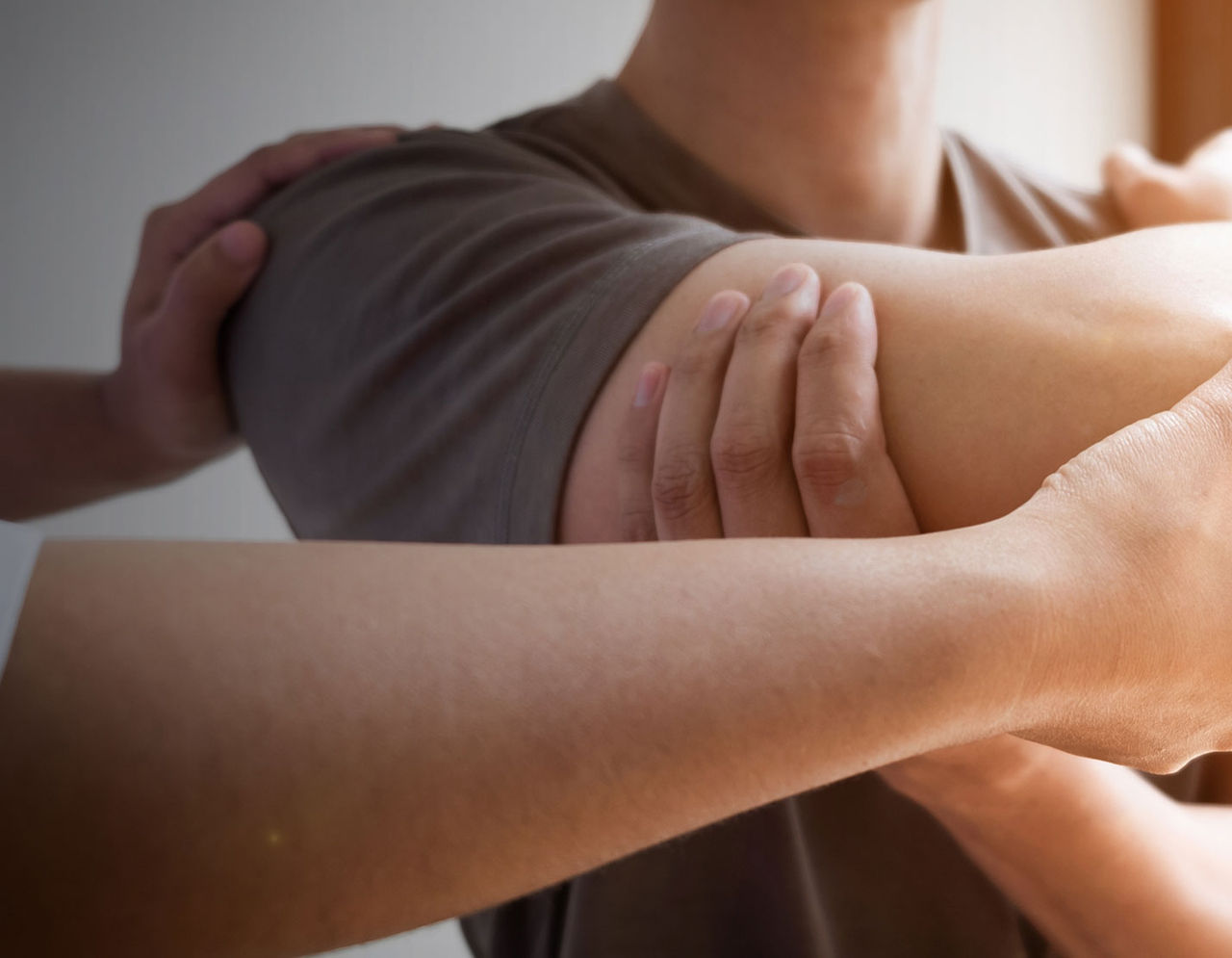 Provider performing shoulder stretches with male patient