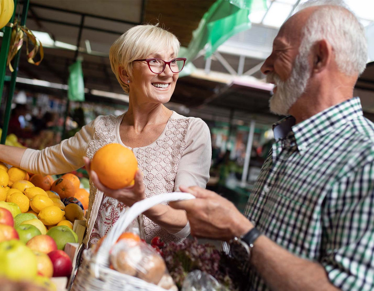Senior couple shopping for fresh fruit at market