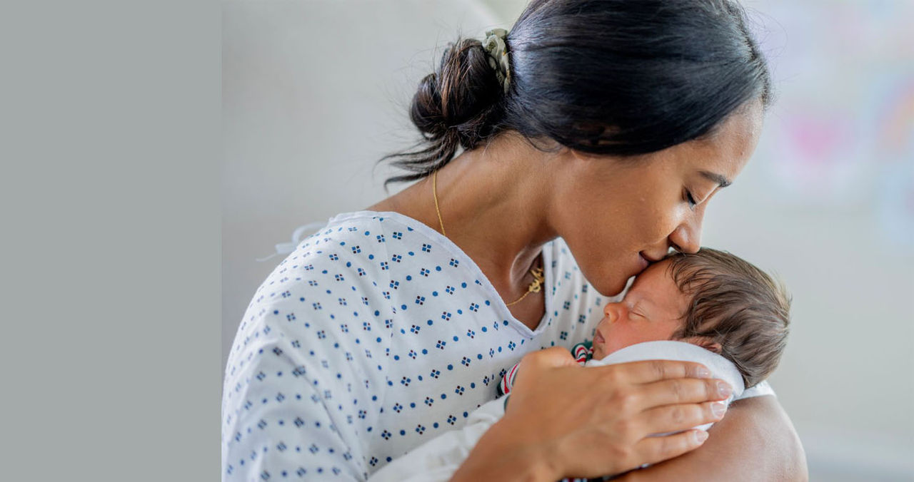 New mother kissing baby