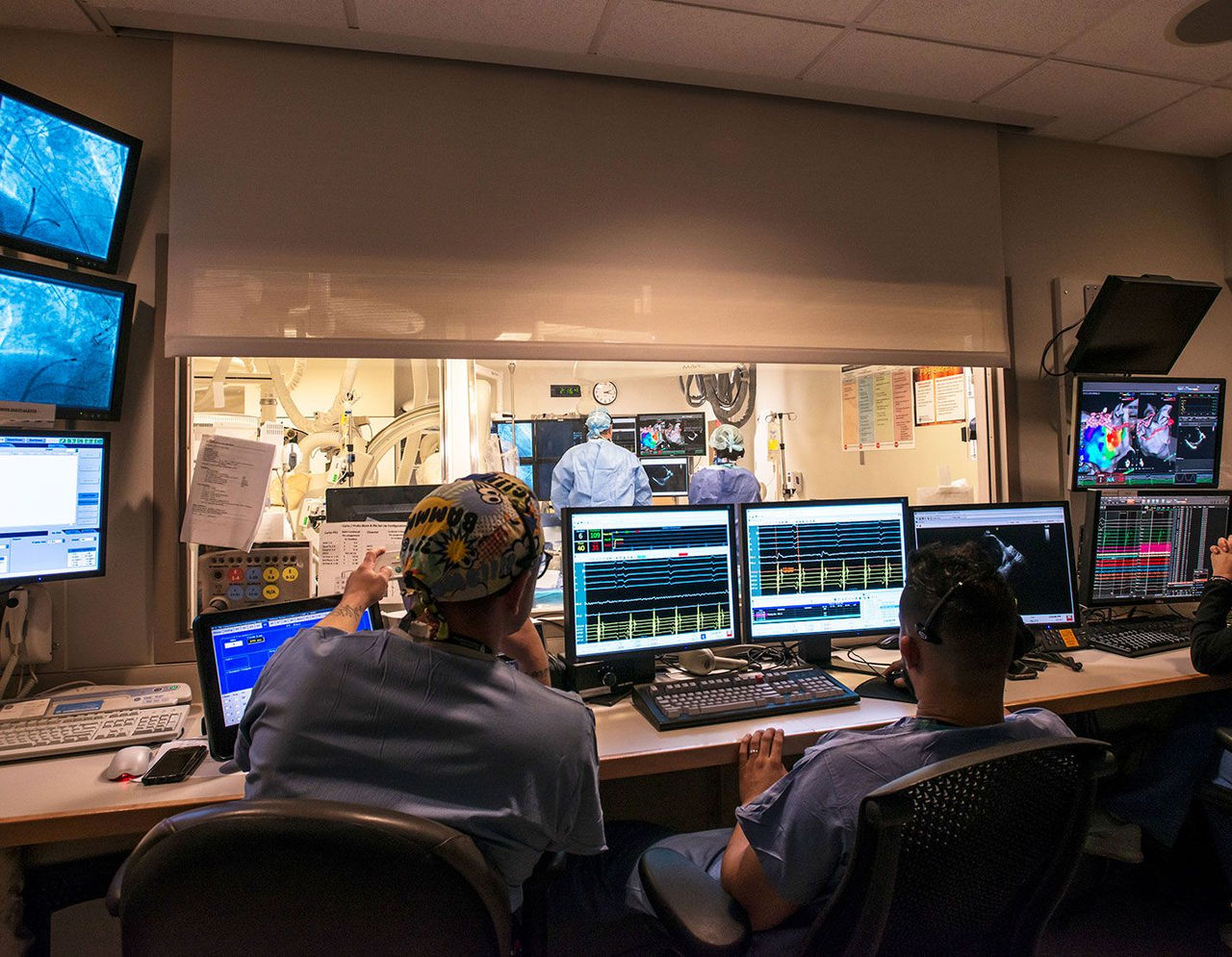 Doctors on the quality and safety team observe heart monitoring on screens 