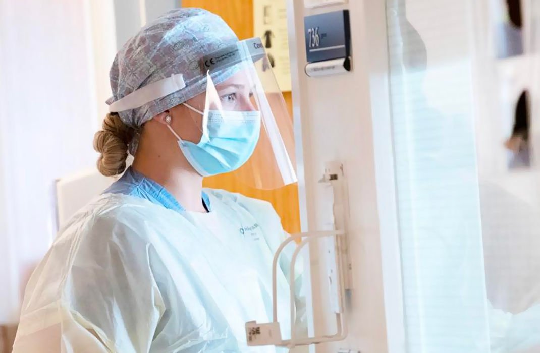 A provider dressed in scrubs enters an exam room