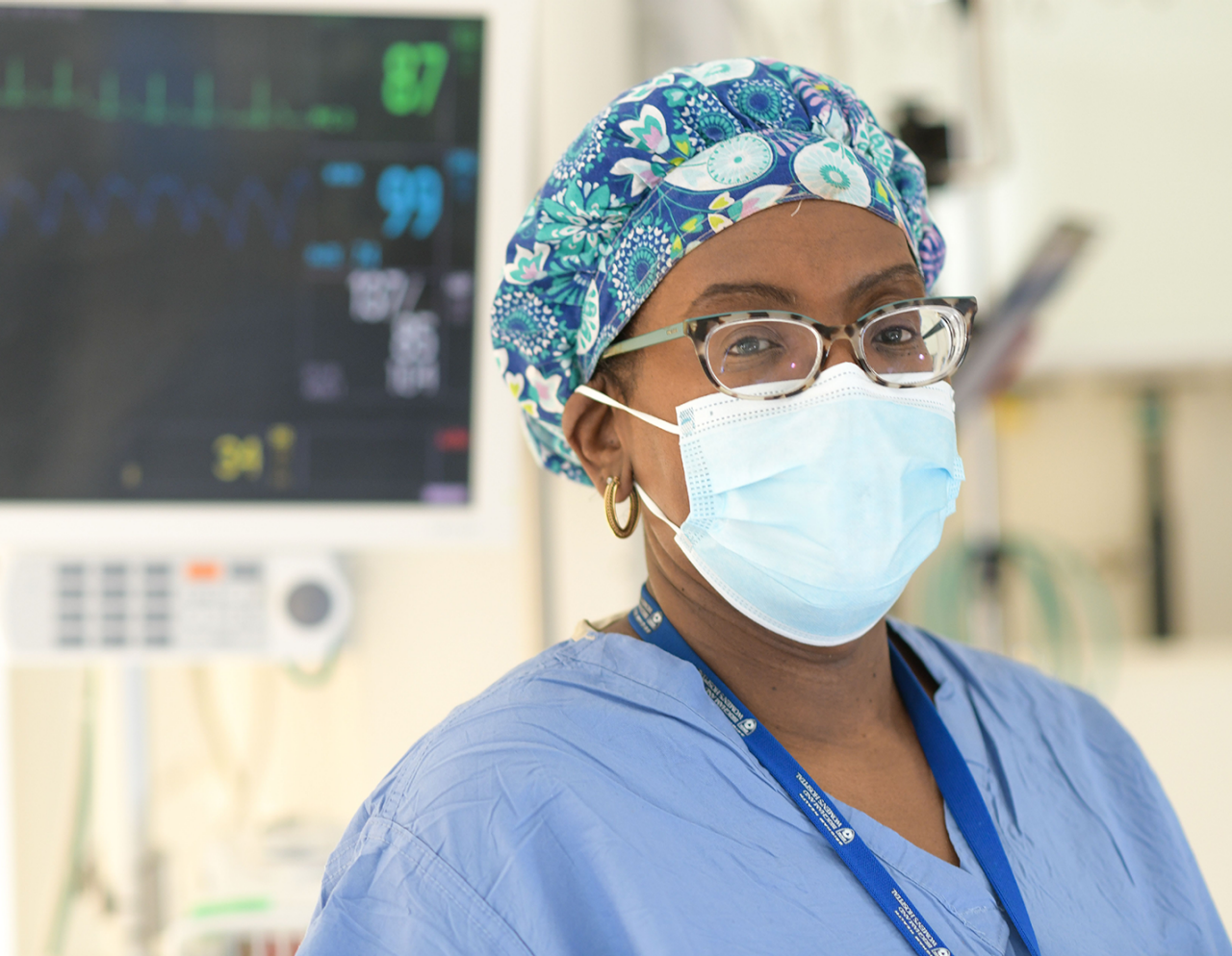 female nurse with mask in front of monitor