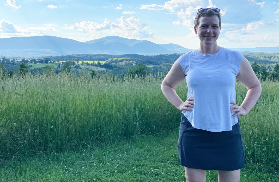 Katie Britton standing in a field, smiling
