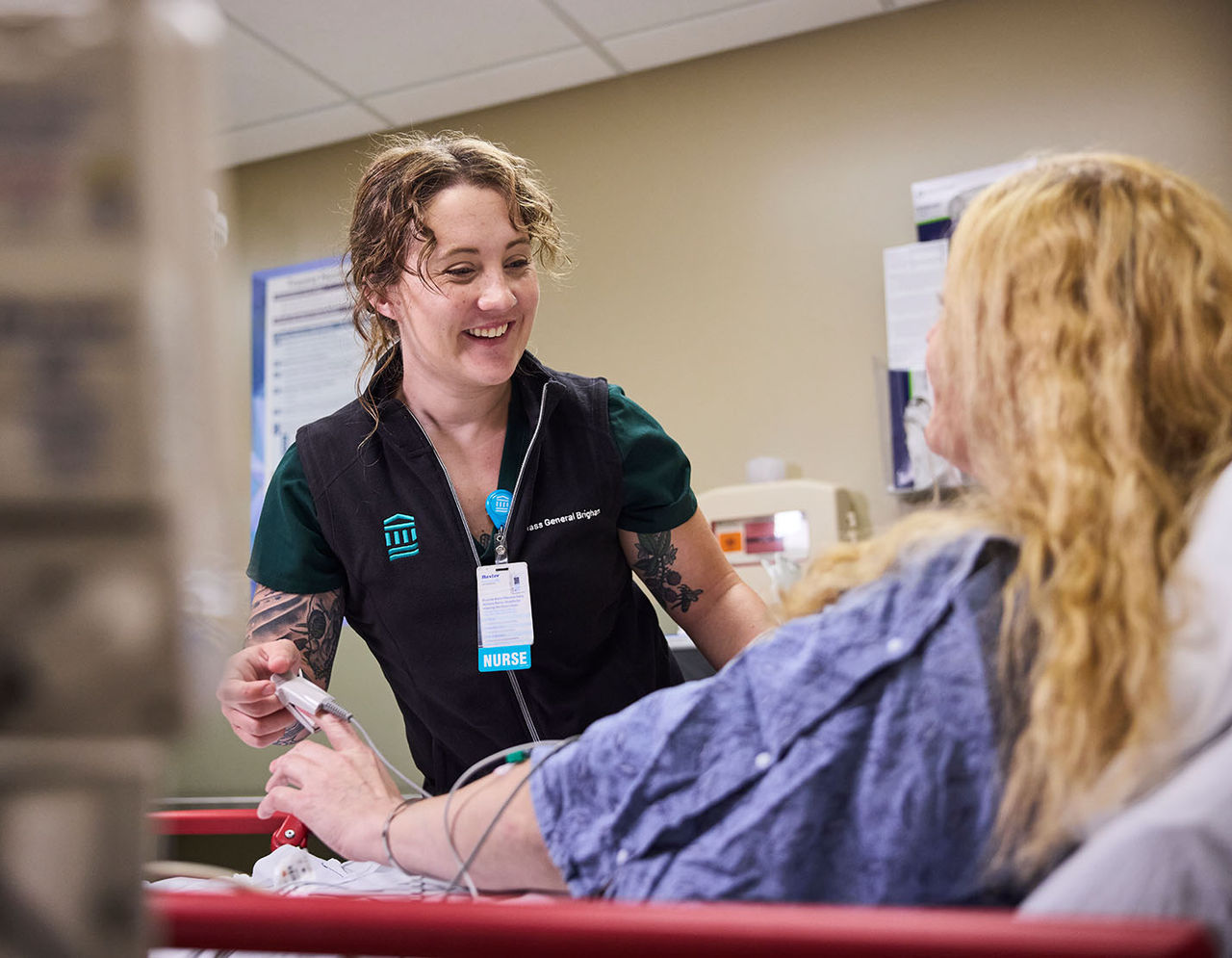 female provider smiling with patient at bedside in an emergency room