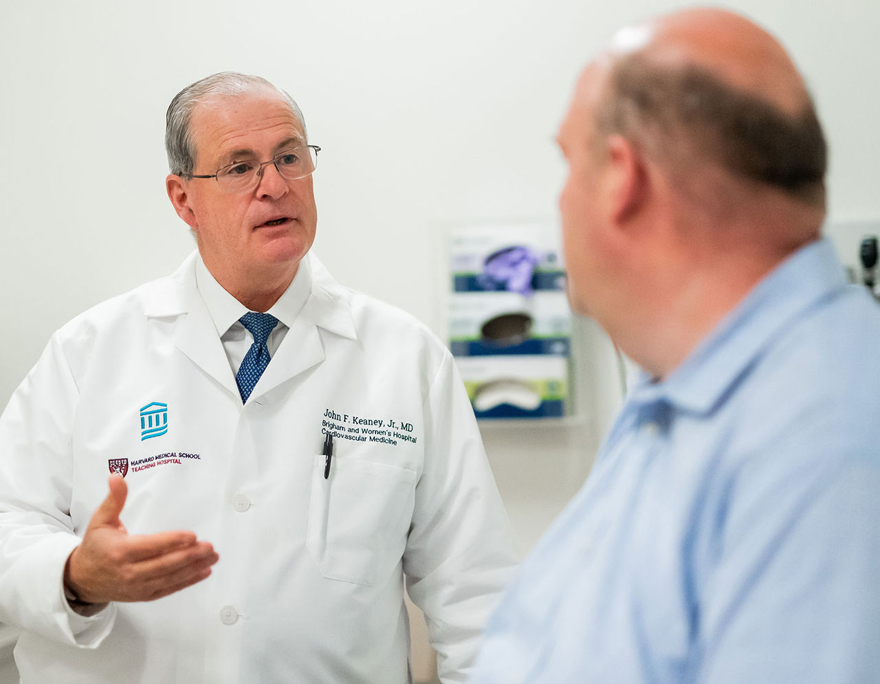 heart provider talking to make patient in exam room