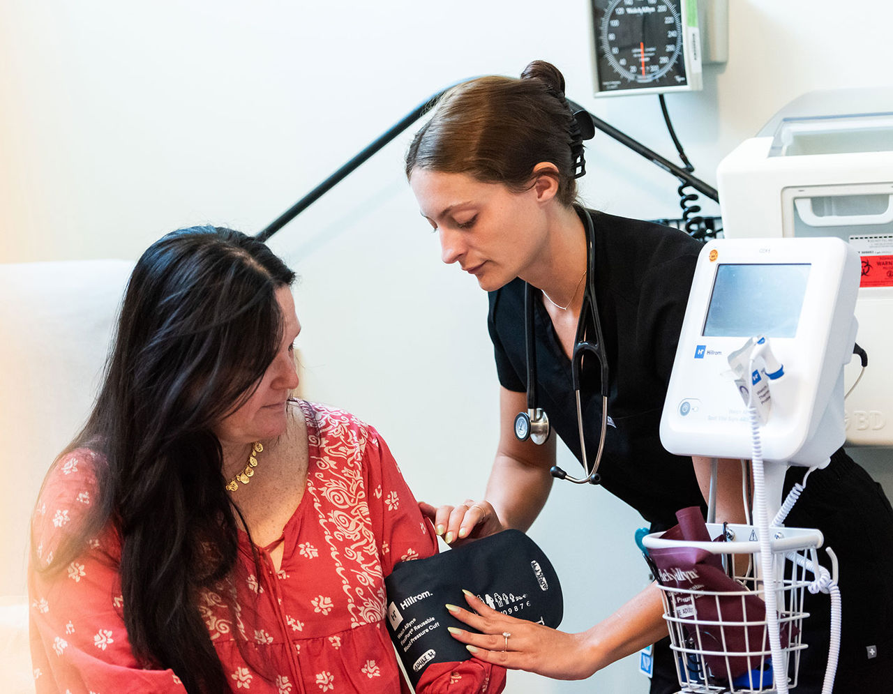 heart provider about to take blood pressure of a female patient