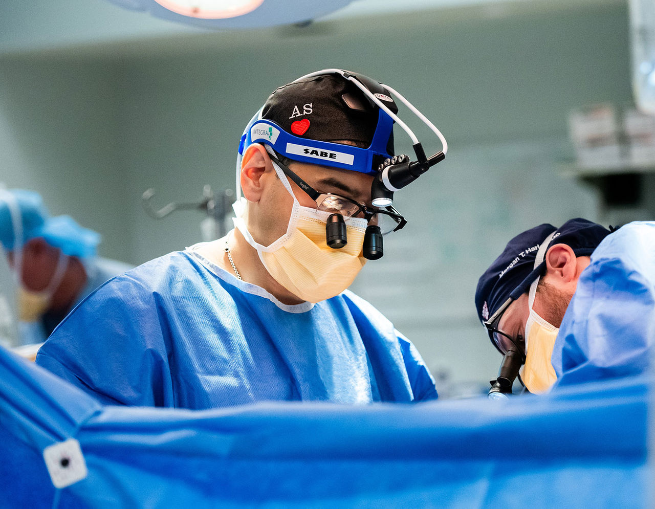 close up of cardiac surgeons operating on patient in operating room