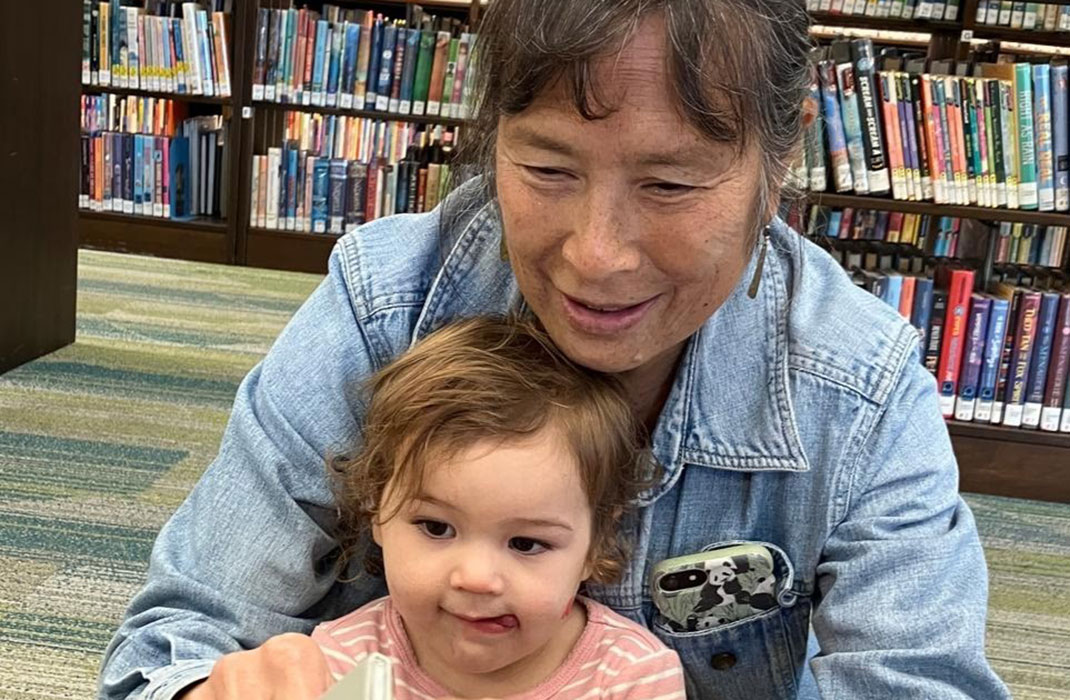 Melody Morse in library with young child