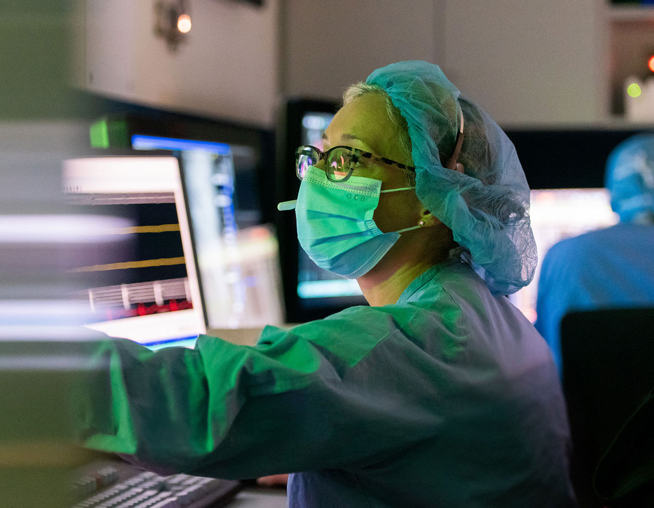 heart provider in scrubs and wearing mask at monitor viewing graphic 