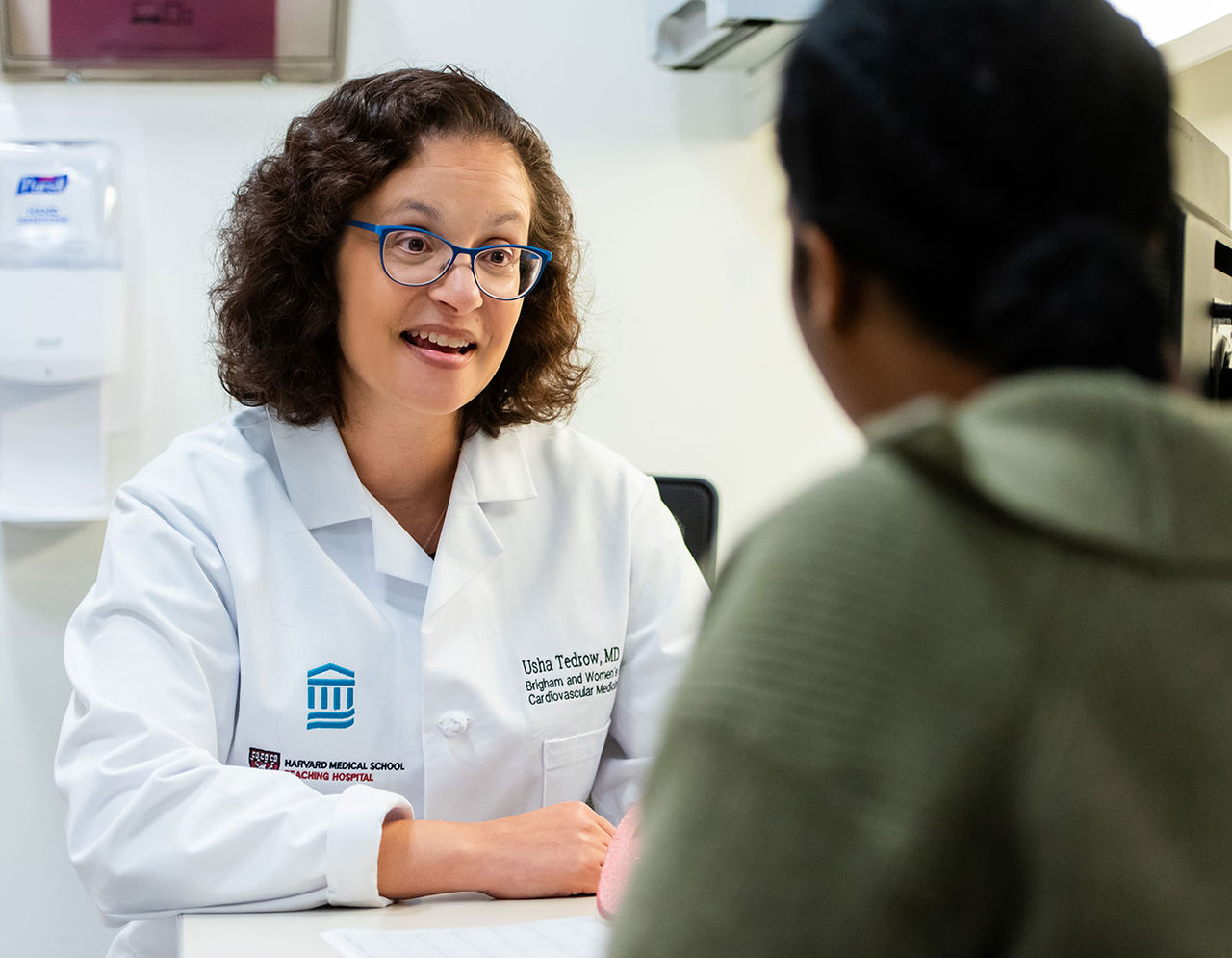 female heart provider in lab coat talking to patient