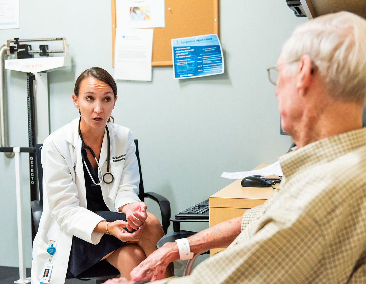 female heart provider talking to older male patient in exam room