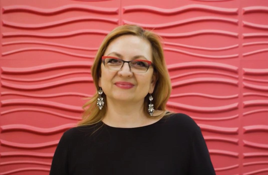 female patient smiling in front of textured wall