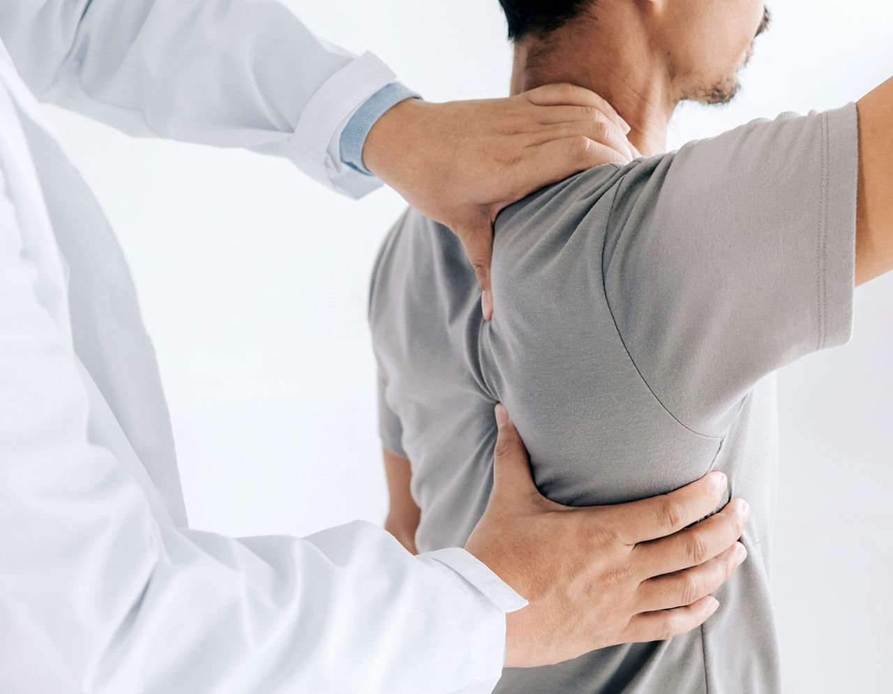 A healthcare professional assists a male patient during a physical therapy session