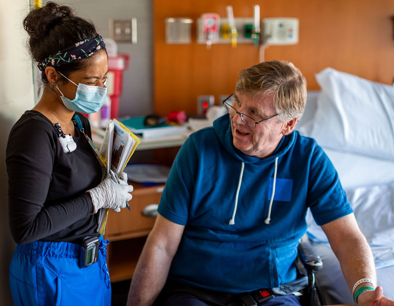 Smiling masked provider with seated patient