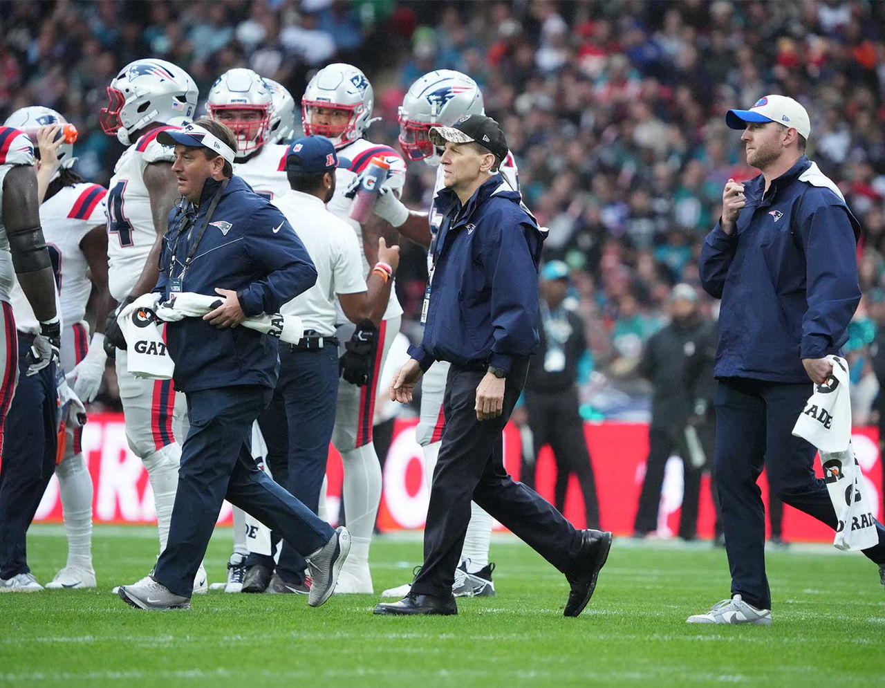 New England Patriots football players and coaches on field during game