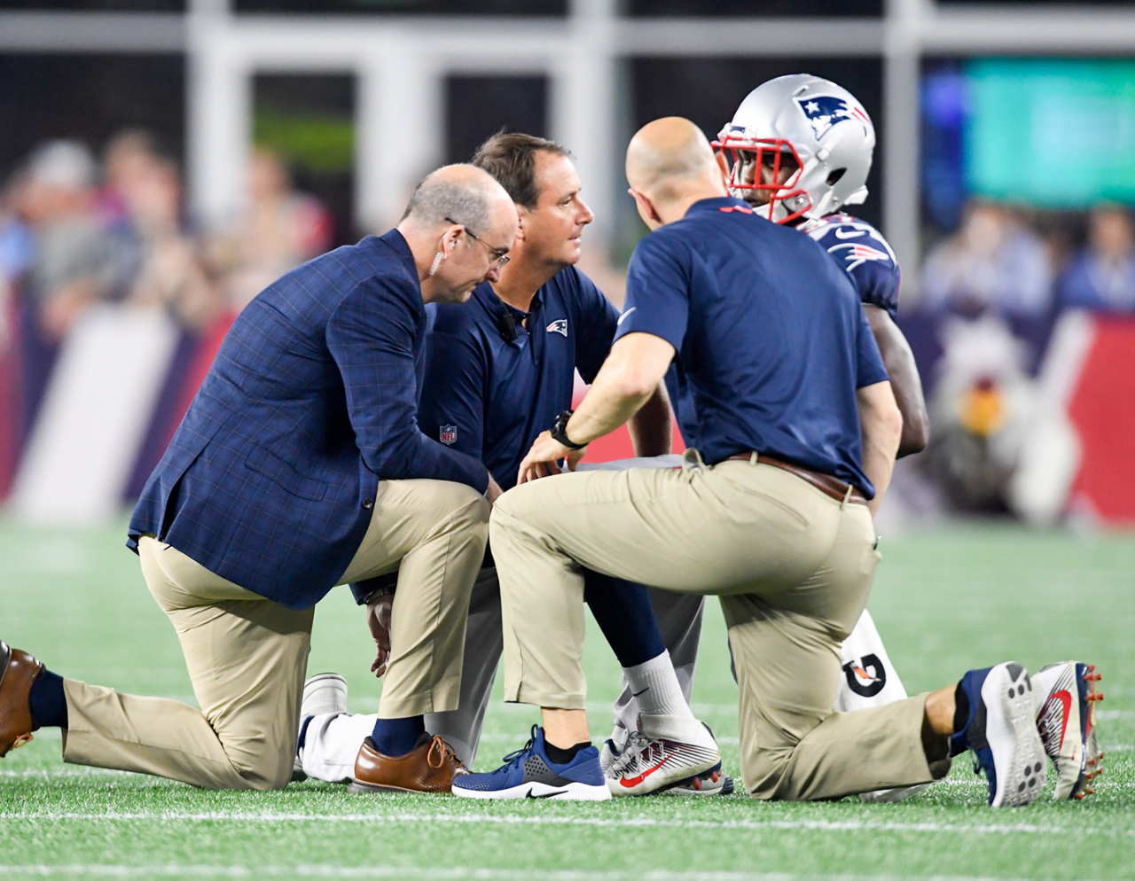 football player on field being examined by care team