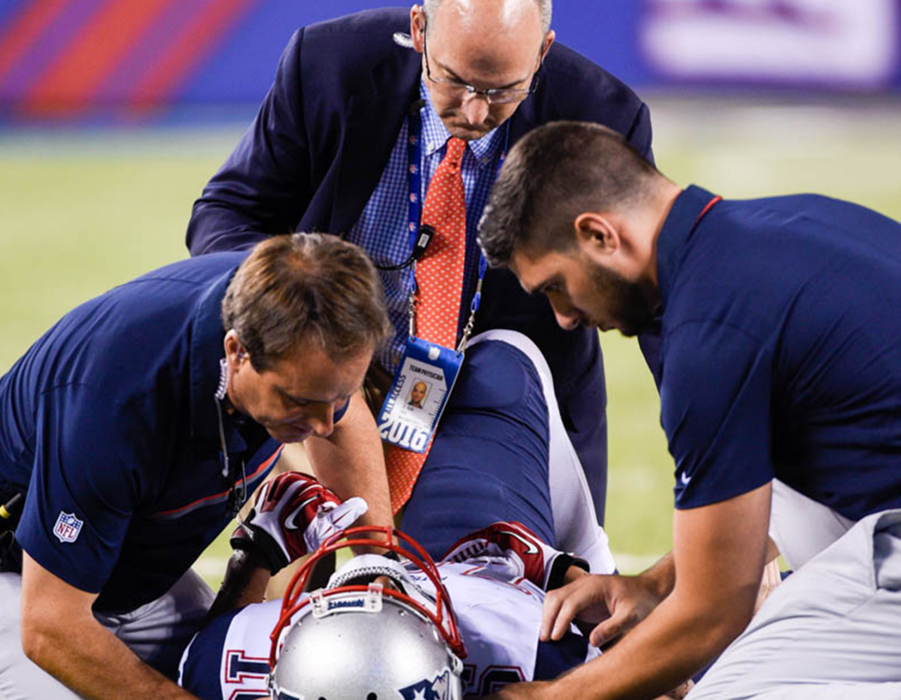 football player on field being examined by care team