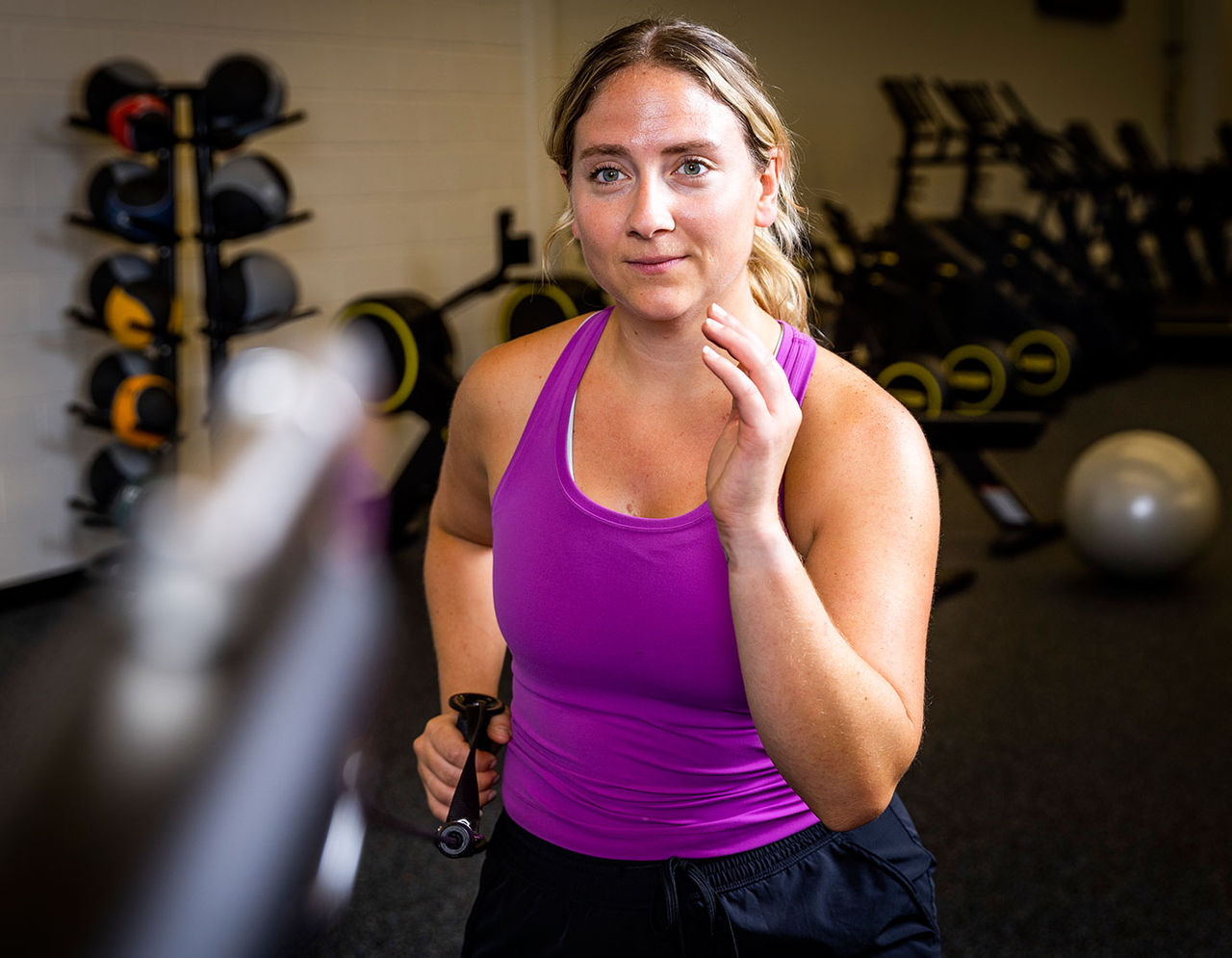 woman at gym using weight machine 