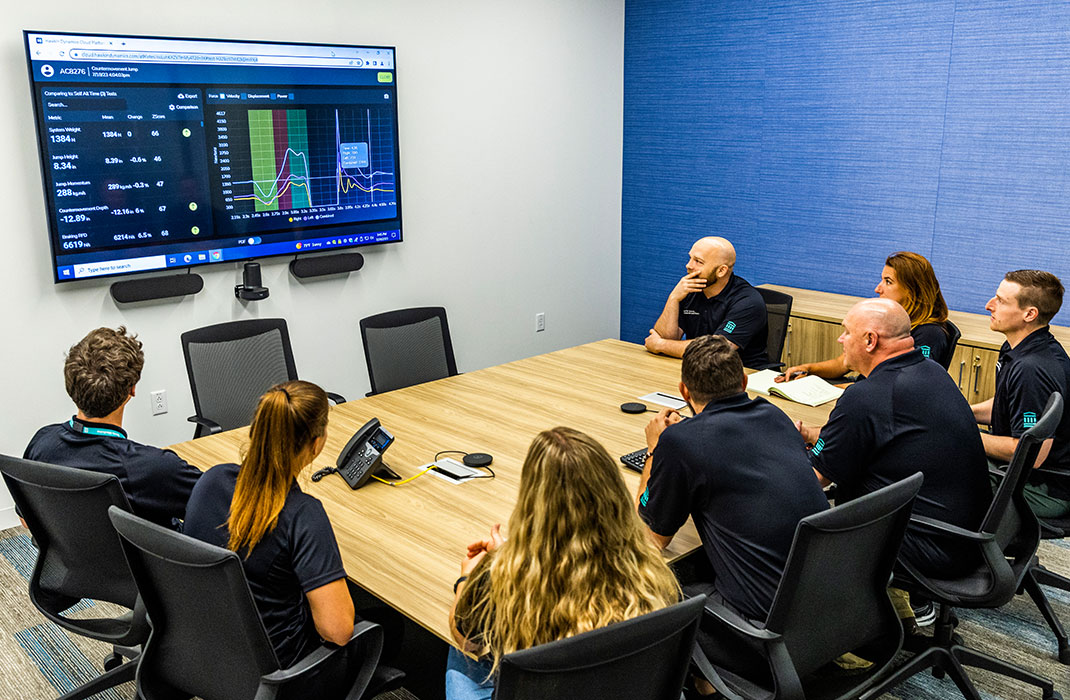 center for sports medicine and research team at conference table viewing data on monitor