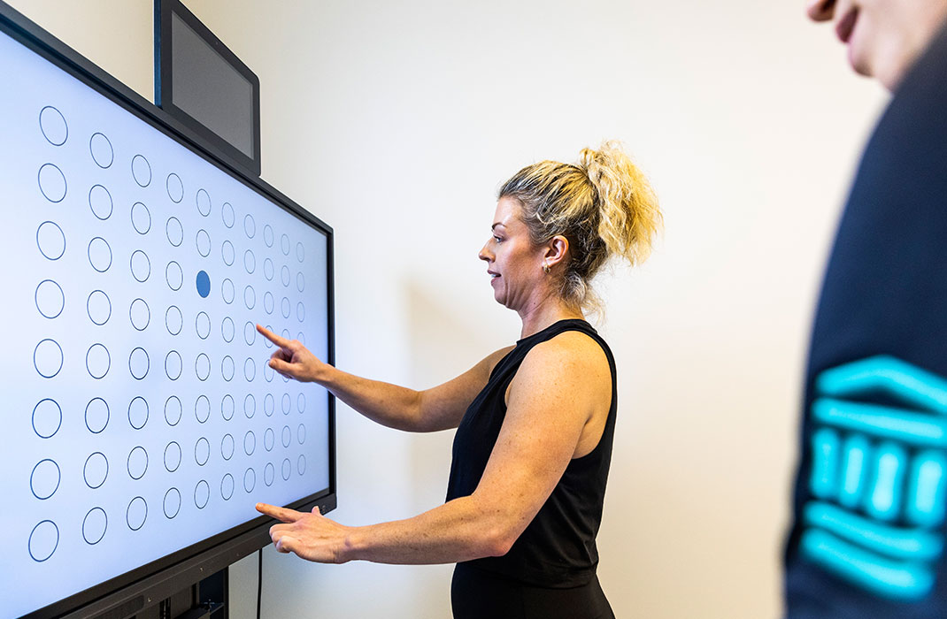 female client pointing to monitor during a cognitive test