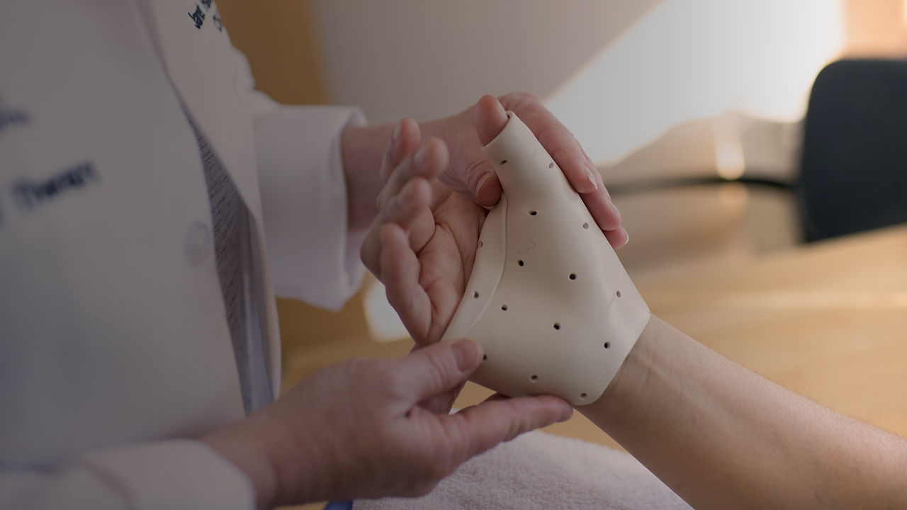 doctor examining hand of patient 
