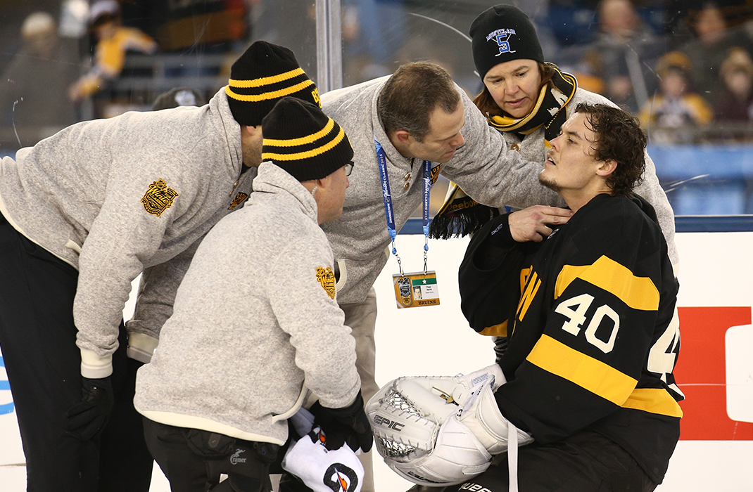 hockey player in the rink being examined by care team