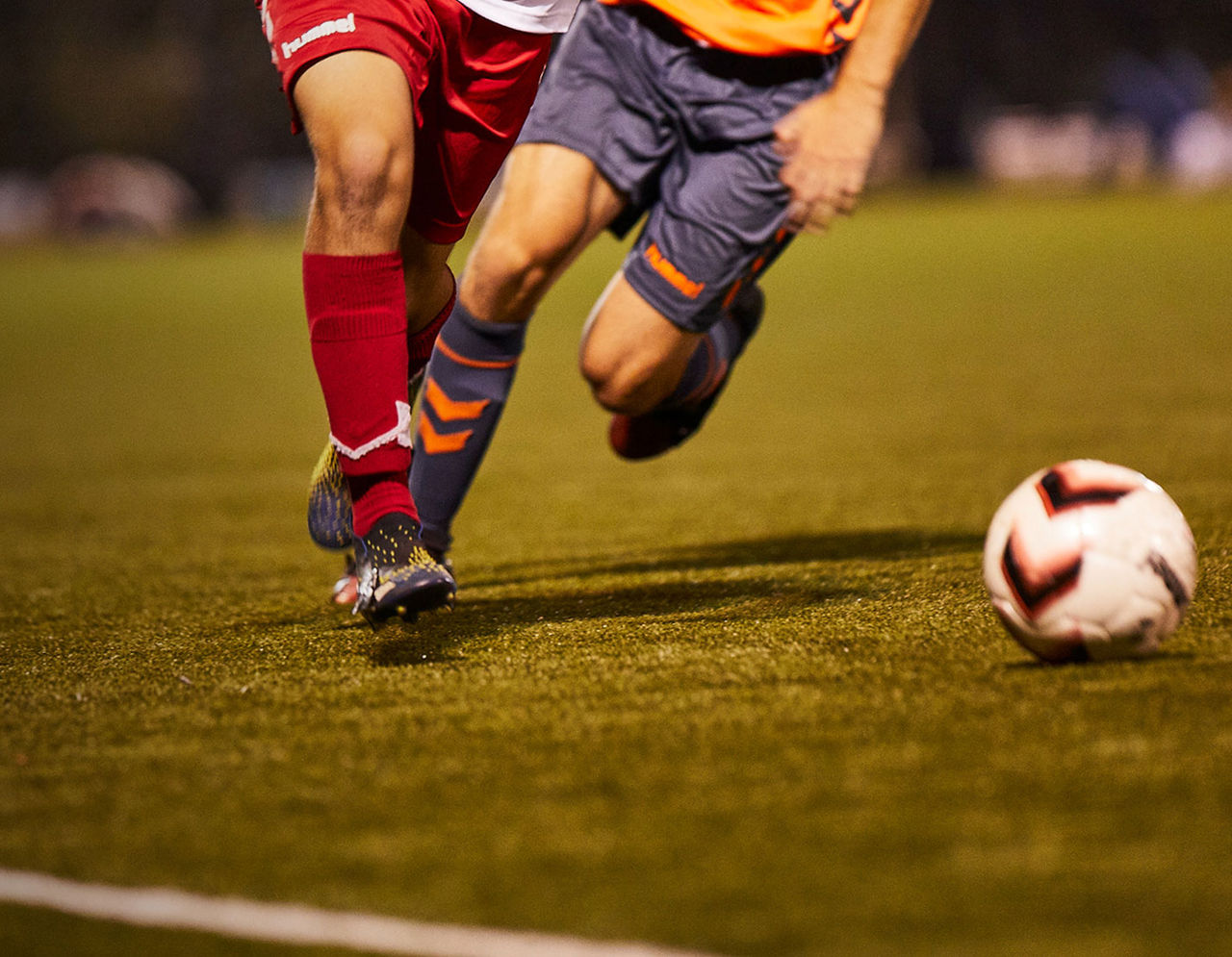 soccer players on field heading towards soccer ball