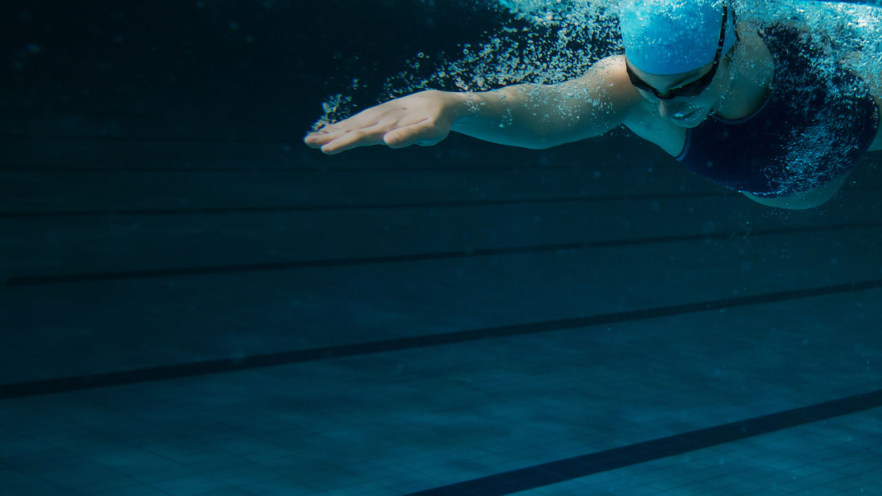 woman in pool swimming under water