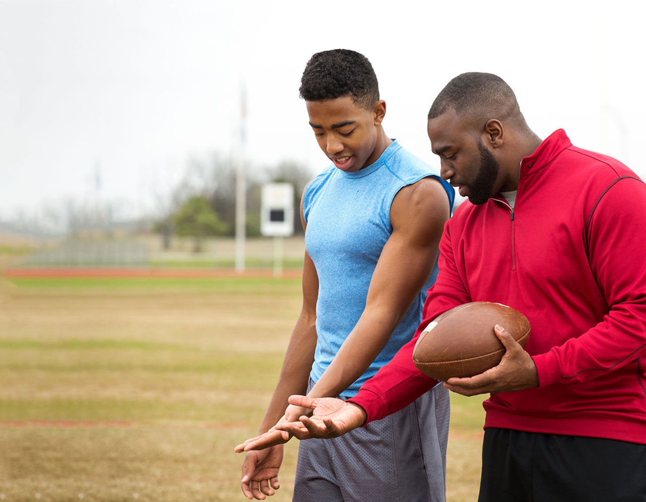 athletic trainer with athelete on football field 